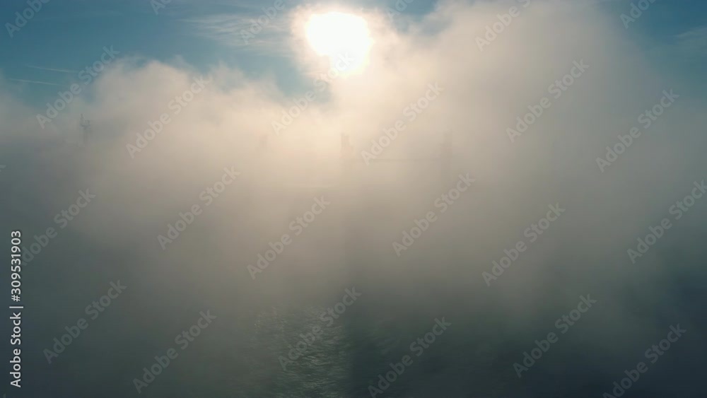 Aerial view of cargo container  ship sails in sea fog, crane vessel working for delivery of delivery containers.