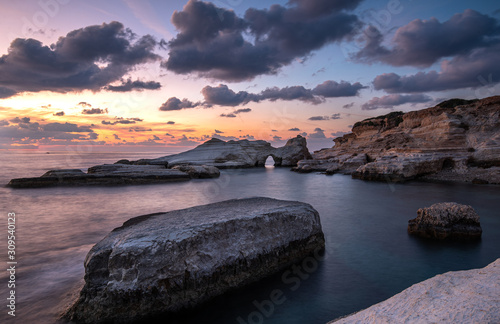 Fototapeta Naklejka Na Ścianę i Meble -  Rocky seashore seascape with dramatic and beautiful sunset at sea caves coastal area  in Paphos, Cyprus
