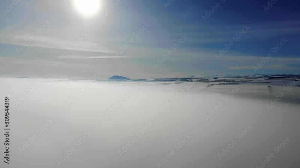 The rise of white fluffy clouds with a beautiful sun rays at the backdrop of mountain peaks and blue sky. The rise of white fluffy clouds with a beautiful sun rays at the backdrop of mountain peaks and blue sky.