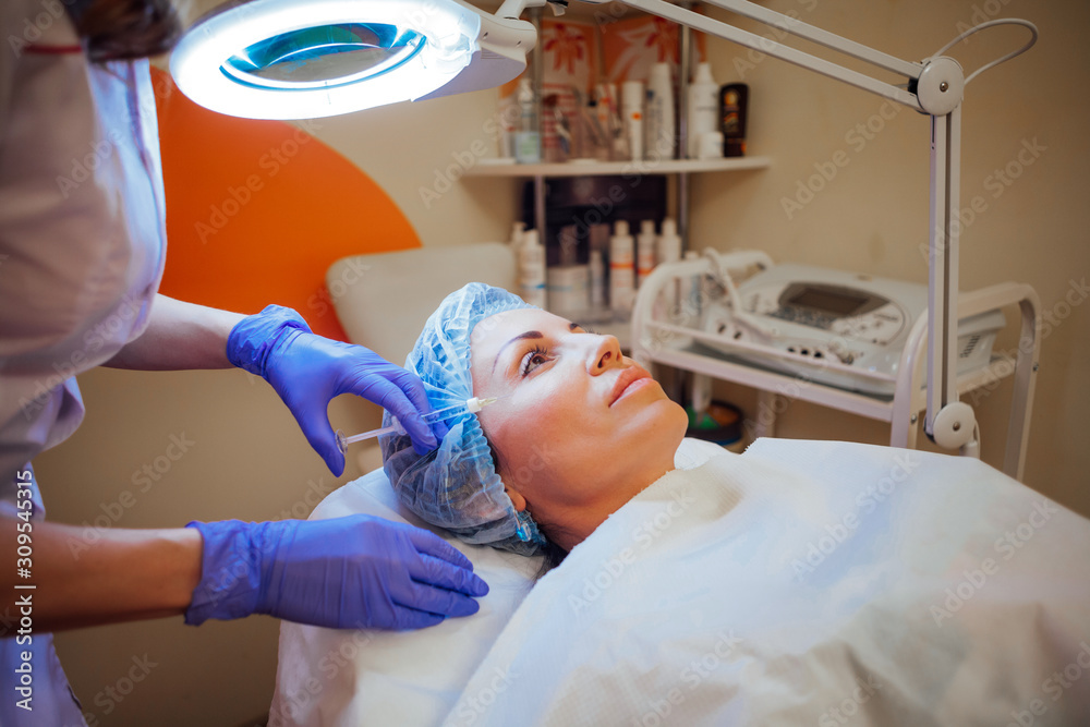 doctor cosmetologist makes injection syringe on the face doctor cosmetologist makes injection syringe on the face