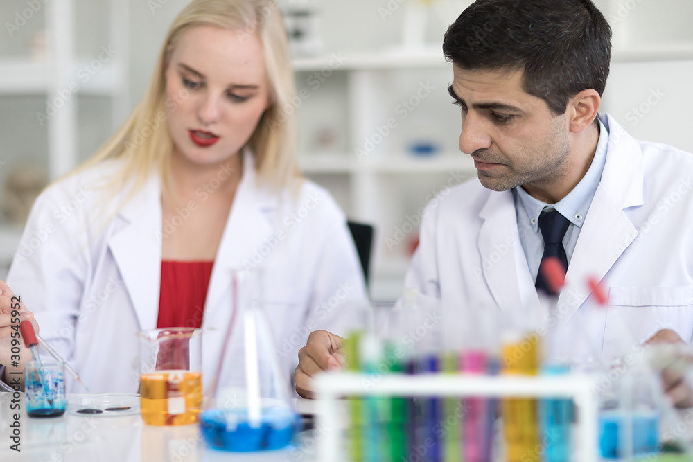 Handsome male scientists and white female scientists are experimenting with chemicals in the laboratory. Handsome male scientists and white female scientists are experimenting with chemicals in the laboratory.