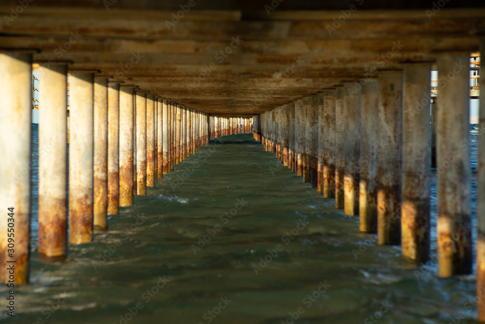 View under a jetty on a sunny evening. Focus far.