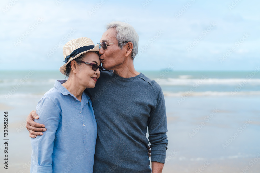 Kissing moment of asian couple senior elder retirement resting at beach honeymoon family together happiness people lifestyle, copy space the right