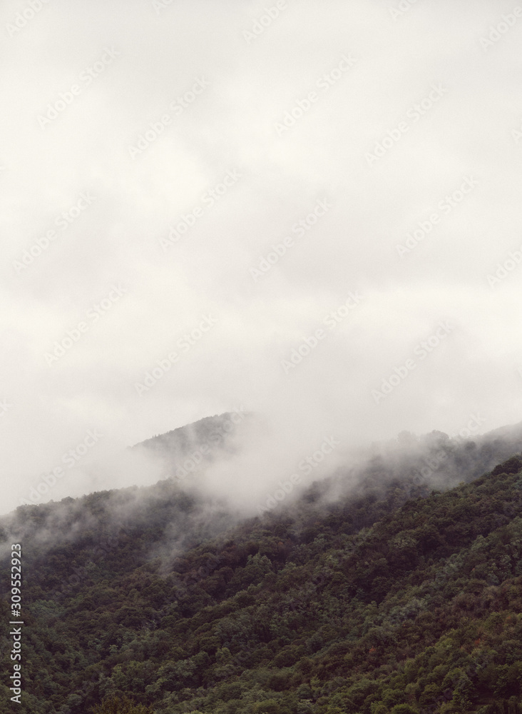 Fototapeta premium Hills hidden by fog on a cold autumn morning