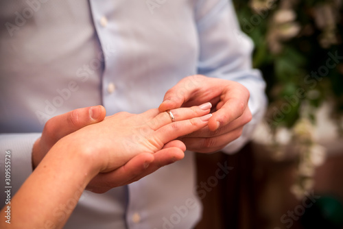 Man wearing a wedding ring on woman's hand. Groom and bride concept. Selective focus. Closeup