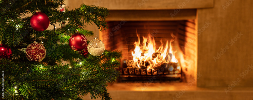 Christmas tree close up on burning fireplace background Christmas tree close up on burning fireplace background