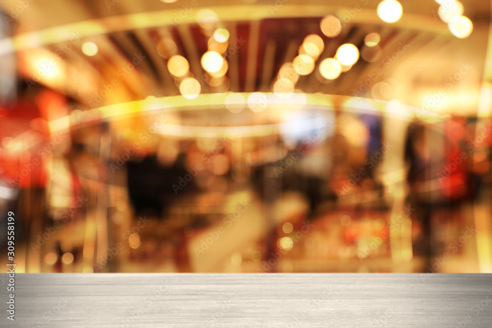 Empty wooden surface and blurred view of shopping mall. Space for design