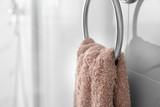Holder with clean towel on light wall in bathroom, closeup