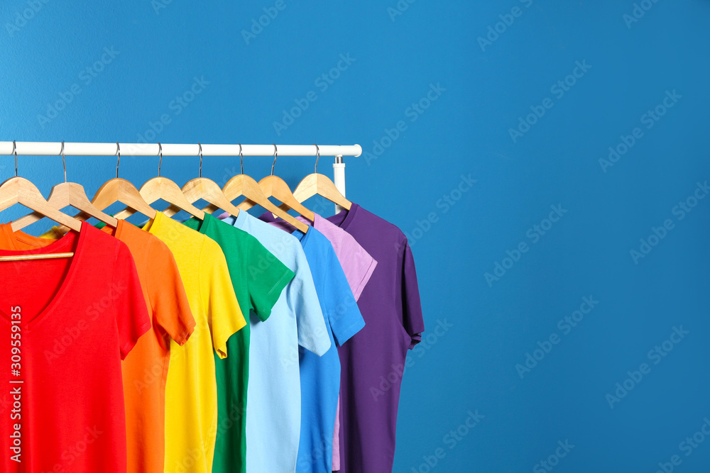 Obraz premium Bright clothes on blue background, space for text. Rainbow colors