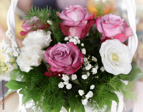 Bouquet of pink and white roses in the white basket 