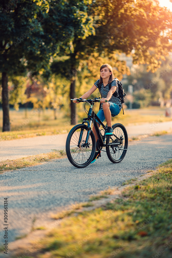 Fototapeta premium School girl riding bicycle