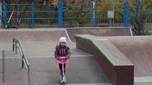 Girl riding a scooter at a skatepark. photo