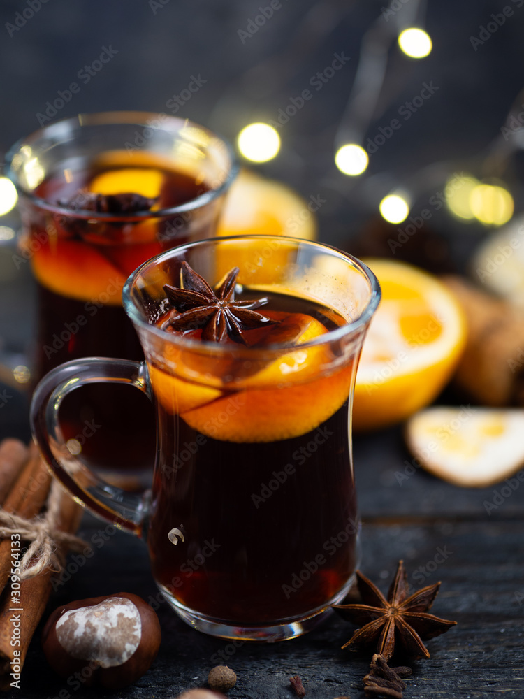 Traditional winter and Christmas hot drink mulled wine on a wooden table . With cinnamon, anise, tangerine Traditional winter and Christmas hot drink mulled wine on a wooden table . With cinnamon, anise, tangerine