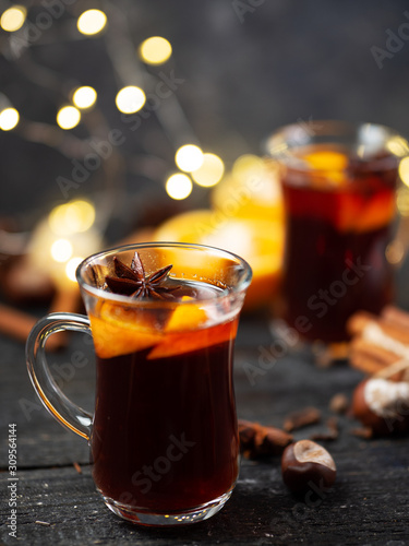Traditional winter and Christmas hot drink mulled wine on a wooden table . With cinnamon  anise  tangerine