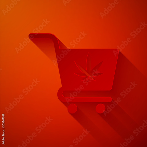 Paper cut Shopping cart with marijuana or cannabis leaf icon isolated on red background. Online buying. Delivery service. Supermarket basket. Paper art style. Vector Illustration