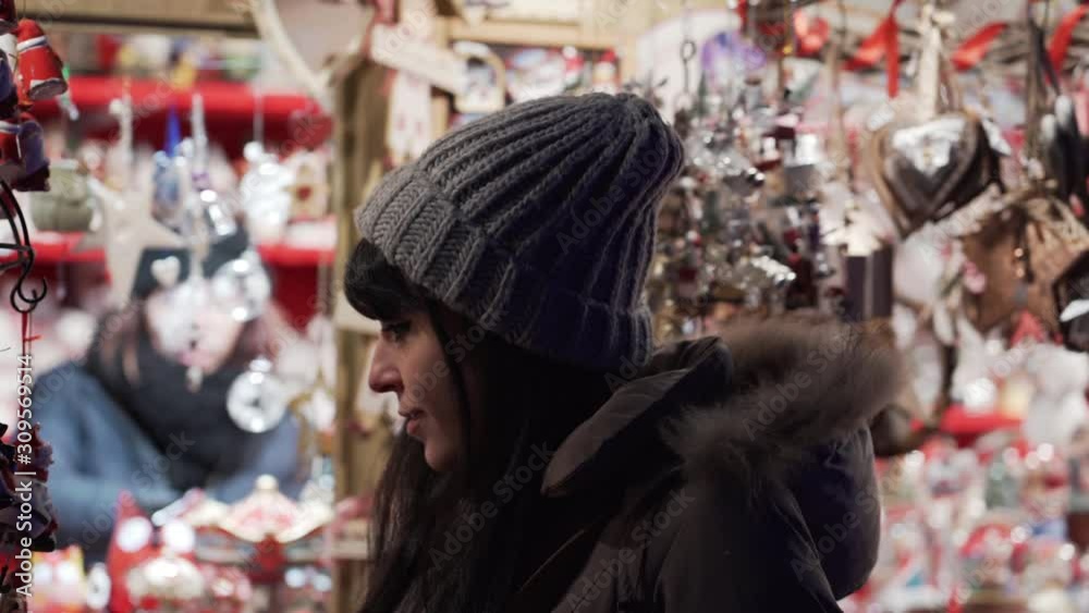 A white young woman snooping for Christmas decoration at Christmas markets in the city