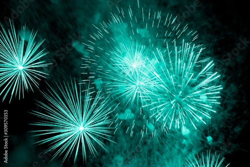 Luxury fireworks event sky show with turquoise big bang stars. Premium entertainment magic star firework at e.g. New Years Eve or Independence Day party celebration. Black dark night background