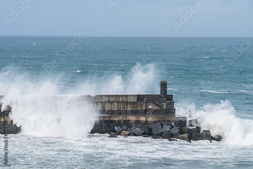 powerful waves breaking at breakwater during a storm
