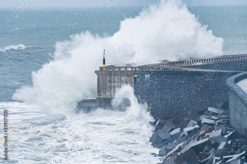 powerful waves breaking at breakwater during a storm