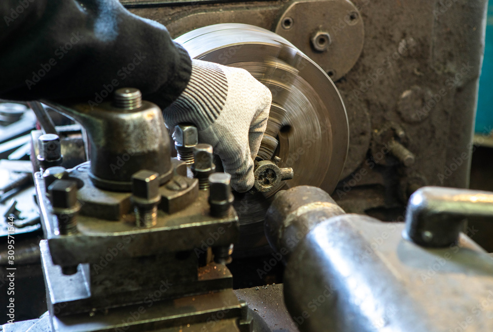 Metalwork equpment. Close-up of lathe and worker`s hand. Thread cutting on a stud. Metalwork equpment. Close-up of lathe and worker`s hand. Thread cutting on a stud.