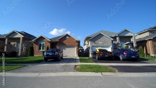 Driving Past Middle Class Neighbourhood Houses Real Estate Side View First Person photo