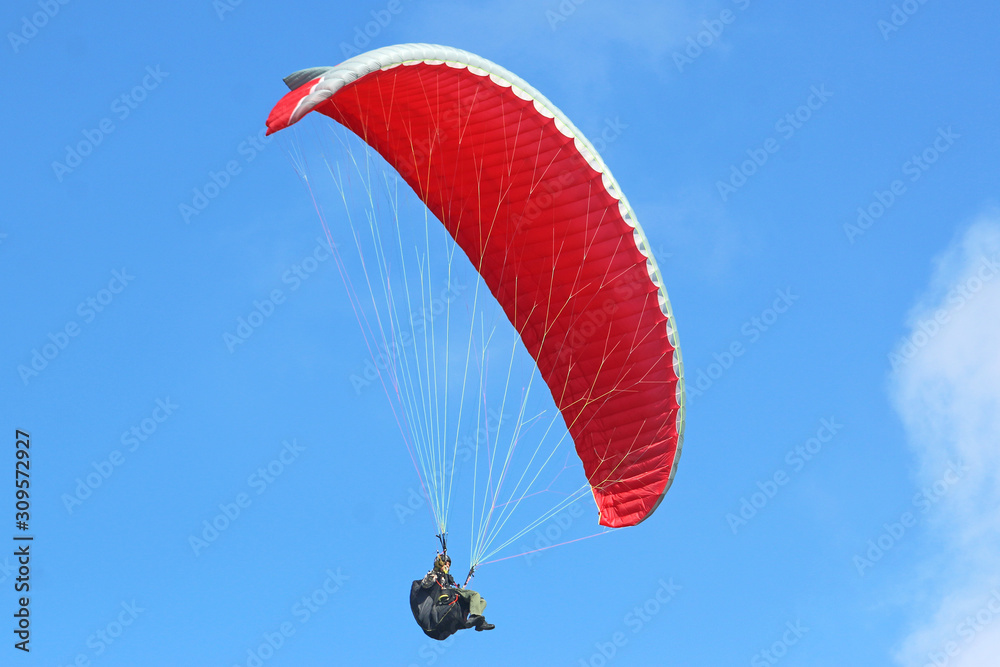 Paraglider flying wing in a blue sky Paraglider flying wing in a blue sky