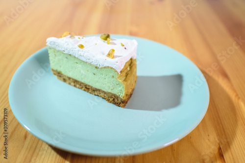Bright and tasty pistachio cake on a large light wooden table