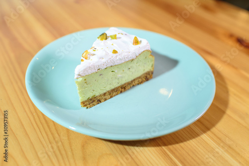 Bright and tasty pistachio cake on a large light wooden table