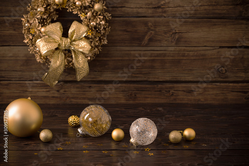 Christmas golden balls and wreath on dark wooden background