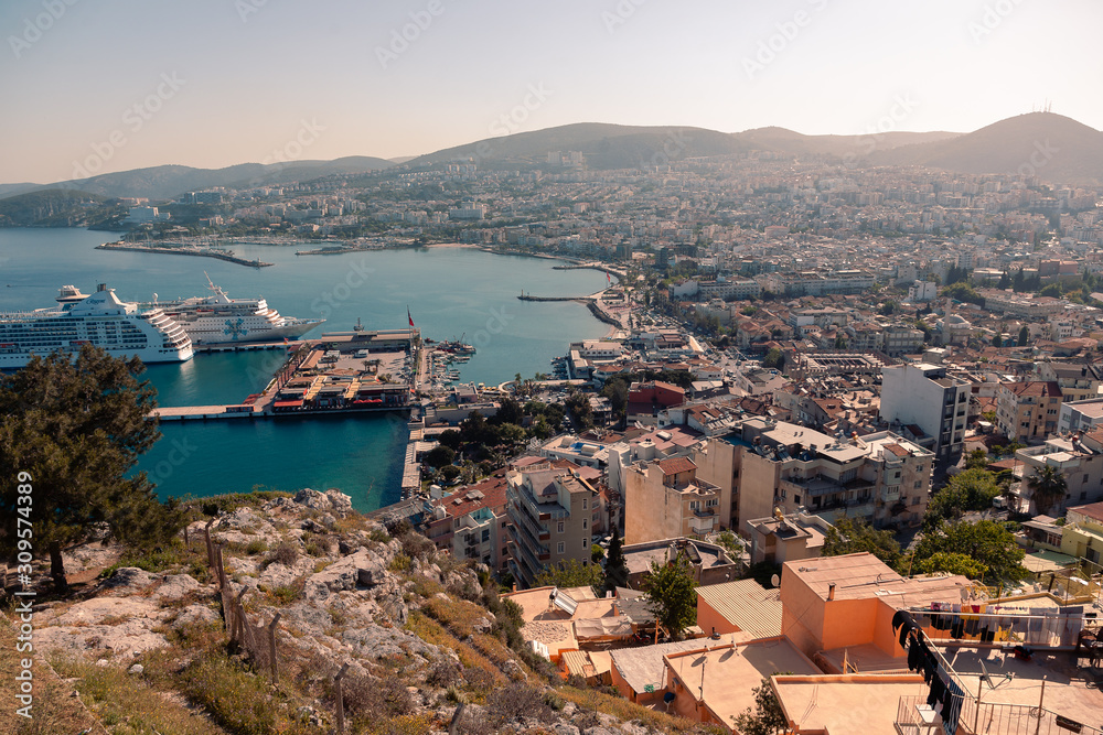 Obraz premium KUSADASI, TURKEY - APRIL 27, 2019: Casual view on the streets near Kusadasi city port side with buildings in sight