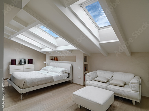 Fotografi interior shot of a bedroom in the modern attic-room in the foreground the leathe