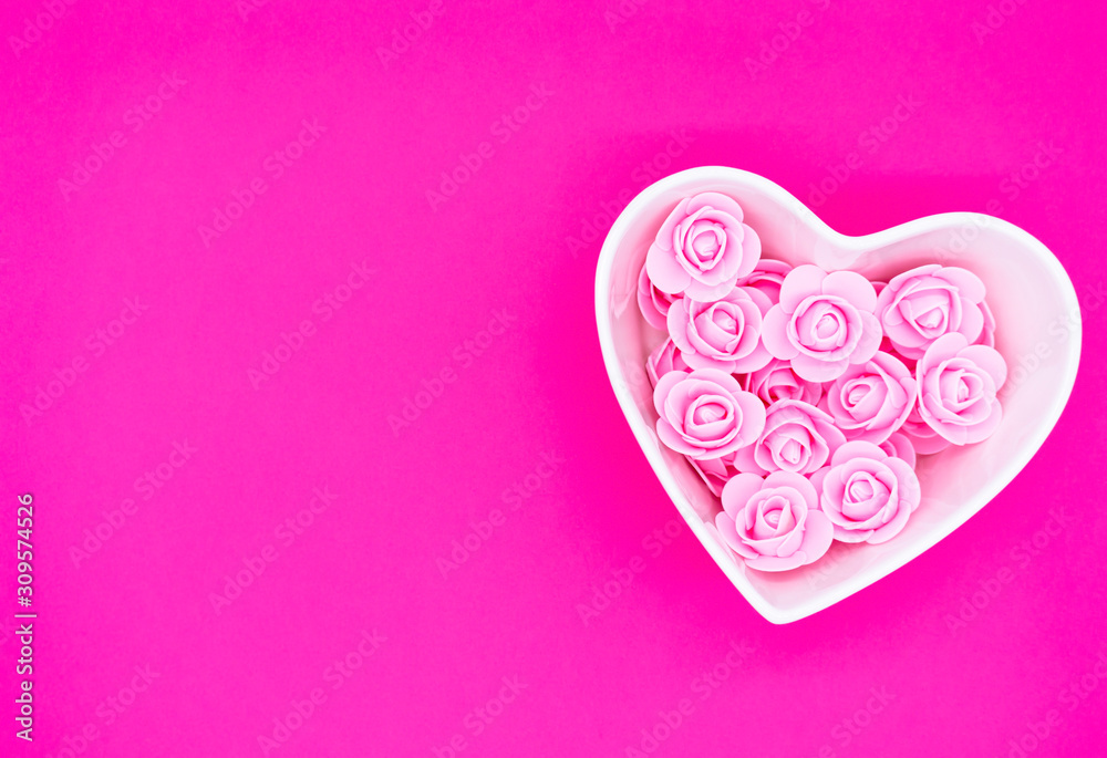 Pink roses in a heart-shaped box on a bright pink background. Valentines day background. Mother's Day, March 8th background.  Flat lay, top view, copy space