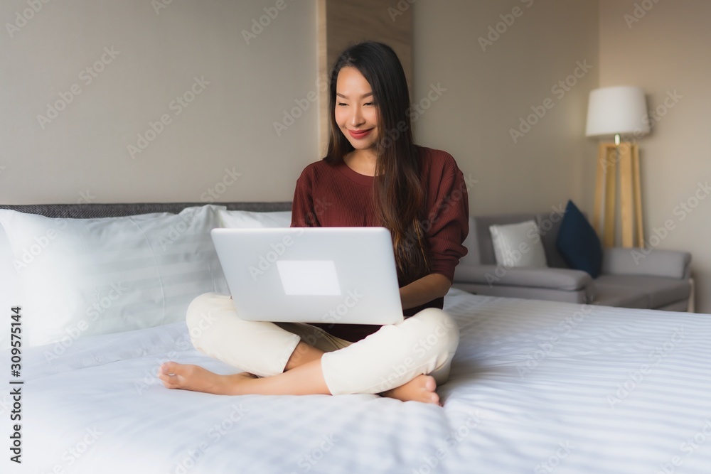 Portrait beautiful young asian women using computer and mobile phone on bed Portrait beautiful young asian women using computer and mobile phone on bed