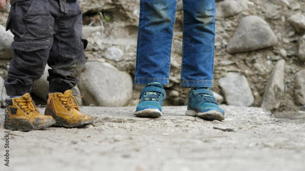Detail of happy children, brothers try to catch a frog, brothers exploring, muddy shoes Detail of happy children, brothers try to catch a frog, brothers exploring, muddy shoes