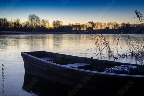 Wooden boat moored on a tranquil frozen lake