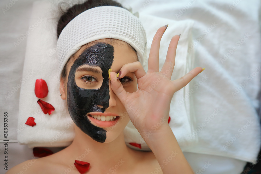 Beautiful young woman relaxing with face mask at beauty spa. Woman
