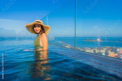 Beautiful young asian women happy smile relax around outdoor swimming pool in hotel resort for travel in holiday vacation