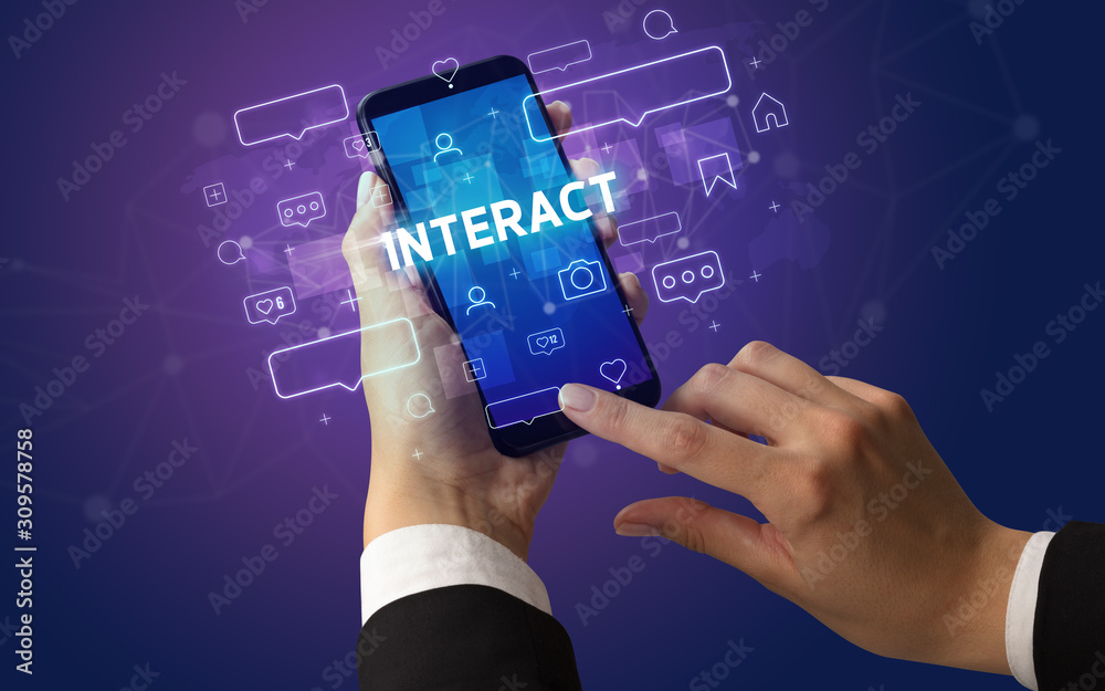 Female hand typing on smartphone with INTERACT inscription, social media concept Female hand typing on smartphone with INTERACT inscription, social media concept