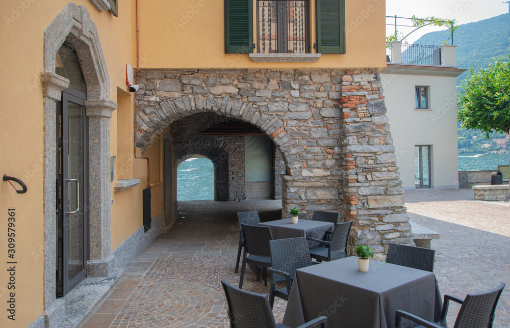 Torno - Italy. Characteristic village overlooking the Como Lake through a stone porch.