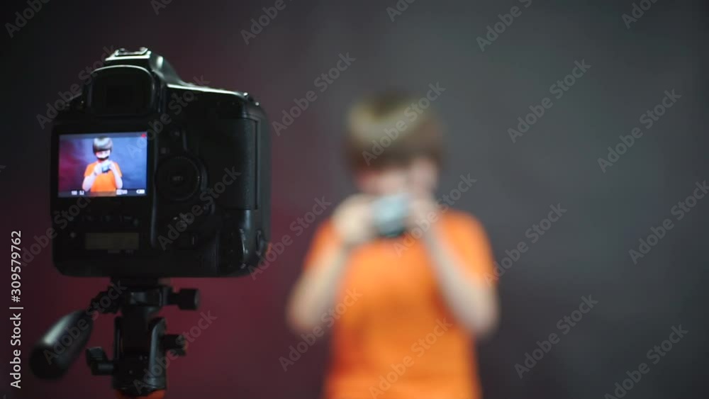 A video blogger with masking tape on his face records a video about the camera. A video blogger with masking tape on his face records a video about the camera.