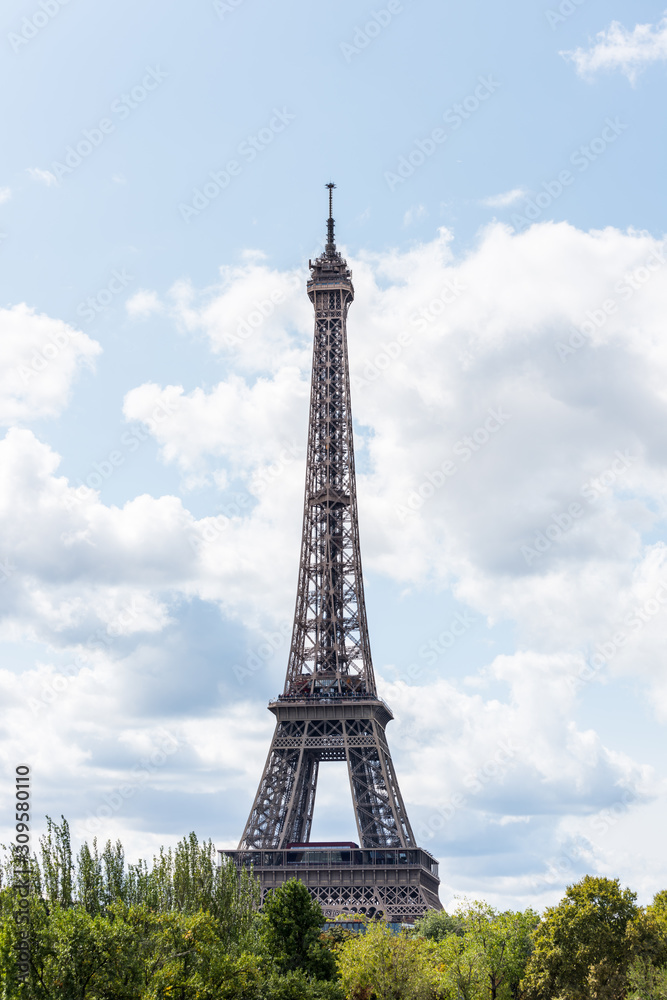 The Eiffel Tower against blue and cloudy sky, a wrought-iron lattice tower on the Champ de Mars in Paris, France, named after the engineer Gustave Eiffel, constructed from 1887 to 1889.