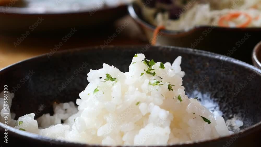 Slow motion Hand with chopsticks Japanese rice in dish on floor restaurant table, Food background concept ,Front view Copy Space. Slow motion Hand with chopsticks Japanese rice in dish on floor restaurant table, Food background concept ,Front view Copy Space.