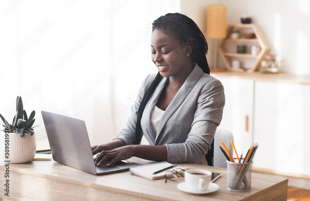 Successful businesslady working on laptop in office - obrazy, fototapety, plakaty 