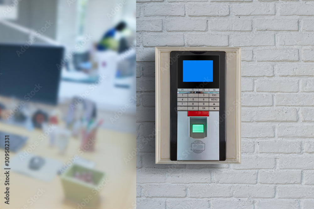 Fingerprint scan machine systems for access interior installed on bricks wall in front of blur office background. Selective Focus. Fingerprint scan machine systems for access interior installed on bricks wall in front of blur office background. Selective Focus.
