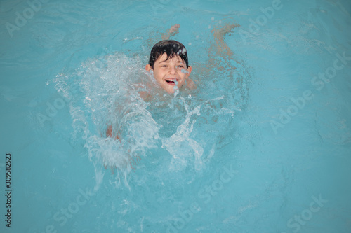 Boy playing in a swimming pool © Juan