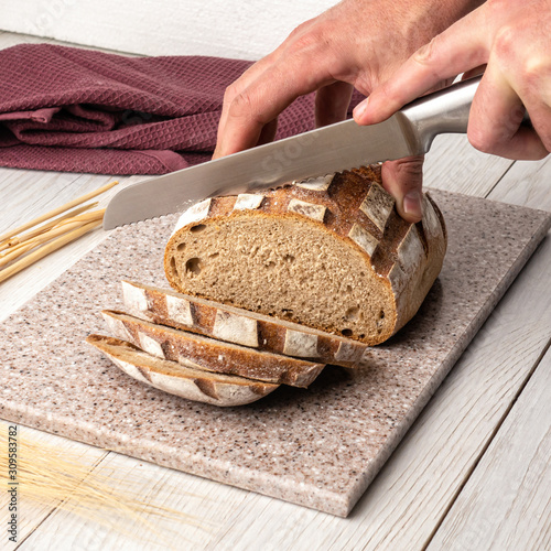 Fresh fragrant bread on a kitchen cutting board made of artificial stone