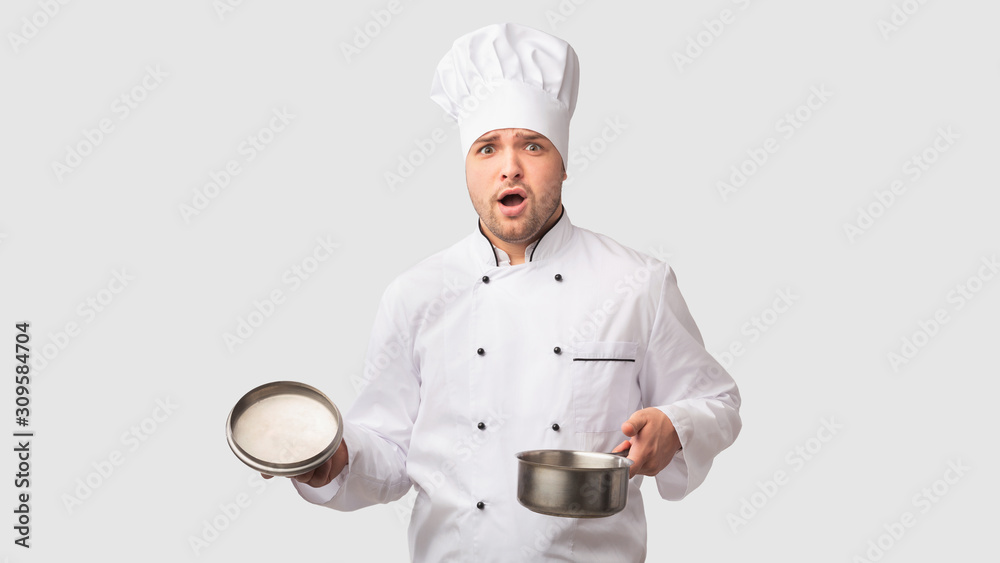 Puzzled Cook Man Opening Saucepan Standing On White Studio Background Puzzled Cook Man Opening Saucepan Standing On White Studio Background