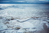 Baltic Sea on wintertime with broken ice cracks. Large pieces of floating ice driven into the seaside. Pack Ice builds up the icebergs. Panorama