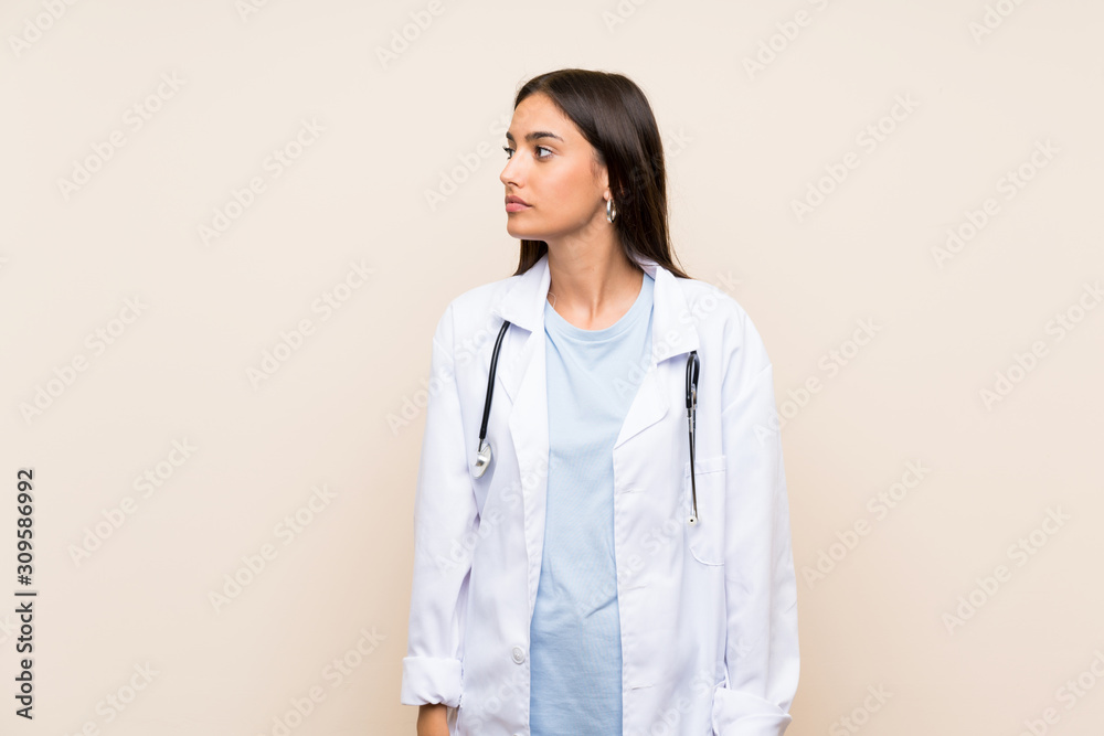Young doctor woman over isolated background looking side Young doctor woman over isolated background looking side