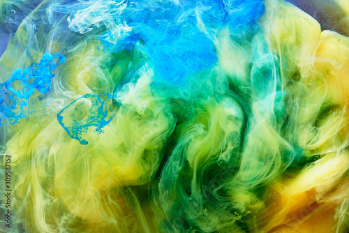 Abstract dancing colorful fume background. Clouds of smoke blue, green and ye...